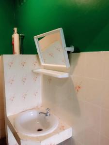 łazienka z umywalką i zieloną ścianą w obiekcie Sam Resort Chaam w mieście Cha Am