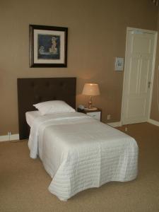 ein Schlafzimmer mit einem großen Bett mit einer weißen Bettdecke in der Unterkunft Hotel Excelsior in Den Haag