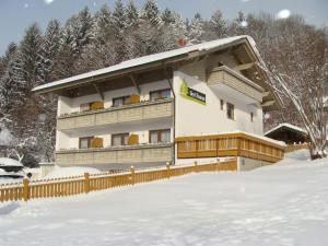 un edificio en la nieve con una valla en Drei Tannen, en Bodenmais