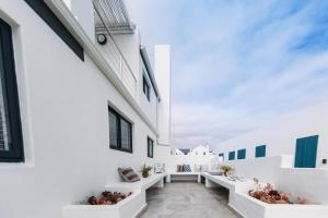 a corridor of white buildings with potted plants at Linhof Boutique Guest House in Paternoster