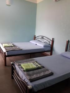 um quarto com duas camas e uma mesa em Canopy Inn em Jerantut