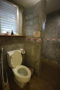 a bathroom with a toilet and a shower at Palita Lodge - SHA Plus in Haad Rin