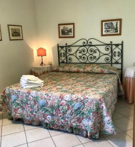 1 dormitorio con 1 cama con colcha de flores en Agriturismo Valle Siriaca, en Castelnuovo di Porto
