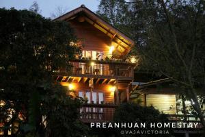 a large wooden house with a balcony at night at Preanhuan Homestay in Mae On