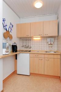 ベンサージールにあるFerienwohnung Schatzinselのキッチン(白い家電製品、木製キャビネット付)