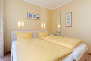 ベンサージールにあるFerienwohnung Schatzinselのベッドルーム(黄色のシーツを使用した大きな白いベッド付)