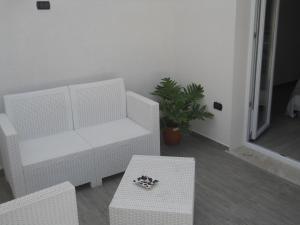a living room with a white couch and a table at Summer Beach Rooms in Fontane Bianche