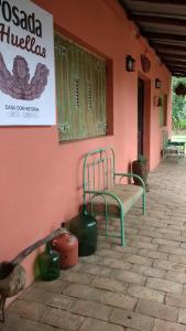 un edificio con dos sillas y un cartel en la pared en Posada de las Huellas en Loreto