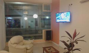 sala de estar con silla y TV en Hotel Victoria en Mar de Ajó