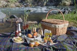 a picnic blanket with food and a basket and wine at Stonecutters Lodge in Lydenburg +72 photos