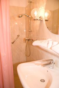 een badkamer met douche, wastafel en toilet bij Hotel Excelsior in Den Haag