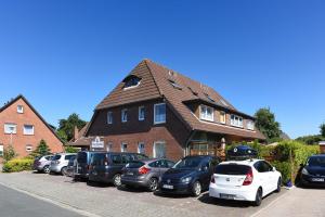 a group of cars parked in front of a house at Haus Stoertebeker in Neuharlingersiel