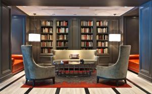 a library with a table and chairs and bookshelves at Melrose Georgetown Hotel in Washington
