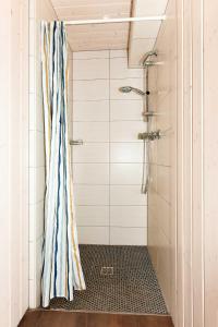 a shower with a striped shower curtain in a bathroom at Haus Stoertebeker in Neuharlingersiel +143 photos
