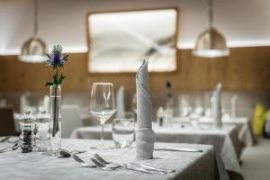 a table with a table cloth with a knife and wine glasses at Hotel La Fradora - Dolomites Hotel in San Cassiano +42 photos