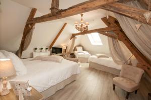 a attic bedroom with two beds and a chandelier at Le Logis Aux Bulles in Verzy