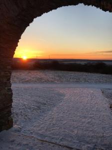 uma vista do pôr-do-sol através de um arco de um edifício em Camberger Ferienhäuschen em Bad Camberg