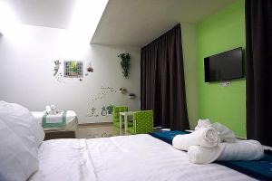 a bedroom with green walls and a bed with towels at D' Cozy Inn in Melaka
