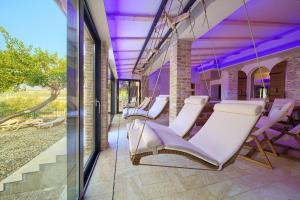 a group of chairs on a porch with purple lighting at Hotel Kanajt in Punat