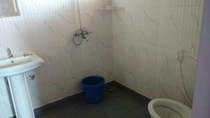 a bathroom with a sink and a toilet and a bucket at Simply Coorg Estate Villa in Virajpet