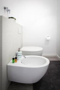 een badkamer met een witte wastafel en een toilet bij L'Appartamento del Corso in Santarcangelo di Romagna