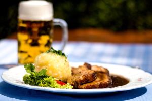 a plate of food on a table with a beer at Kuschelige Ferienwohnung in Schwandorf in Bayern +15 photos