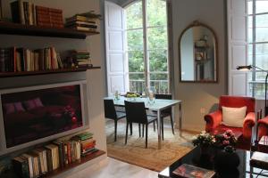 a living room with a table and a fireplace at Luxurious 2 bedroom flat in a historic building in Seville