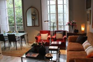 a living room with a couch and chairs and a table at Luxurious 2 bedroom flat in a historic building in Seville