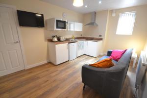 a living room with a couch and a kitchen at Premier Lodge Central in Wolverhampton