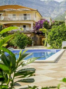 a house with a swimming pool next to a building at Apartments Iva in Orebić