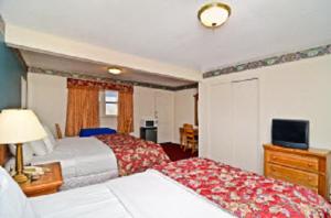 a hotel room with two beds and a television at Americas Best Value Inn - Stonington in Stonington