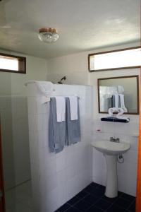 uma casa de banho com lavatório, espelho e toalhas em Costa De Cocos em Xcalak