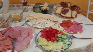 a table topped with plates of different types of food at Zita Haus in Bük