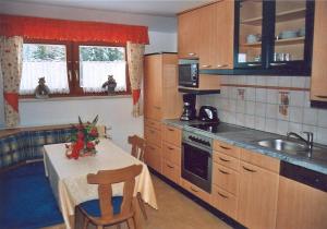 uma cozinha com uma mesa, um lavatório, uma mesa e cadeiras em Gästehaus Jäger em Mariapfarr