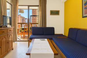 a living room with two blue couches and a tv at Apartamentos Gemelos 2 y 4 by Gestaltur in Benidorm