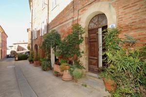 a brick building with a door and many potted plants at Romantico 36 in Città della Pieve