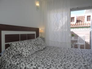 a bedroom with a bed with a black and white comforter at Casa las tres Conchas (2) in Yunquera