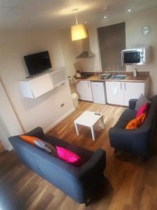 a living room with two couches and a kitchen at Premier Lodge Central in Wolverhampton
