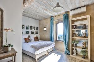 a bedroom with a bed and a window at Apartments - Experience of PROVENCE in Gordes
