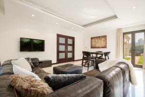 - un salon avec un canapé et une table dans l'établissement Designer 3 Story Palm Villa, à Dubaï