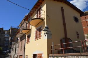 a building with two balconies and a clock on it at Guest House - Il Granaio in Norma