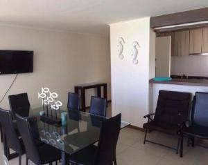 a dining room with a glass table and chairs at Departamento en La Serena in La Serena