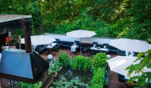 a patio with tables and umbrellas and a pond at Restaurant & Logis Steuerndieb in Hannover