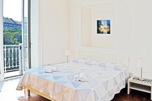 a white bedroom with a bed with towels on it at I Giardini Del Re in Naples