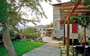 a garden with a table and chairs and a house at Arhontiko Prepala in Neochori