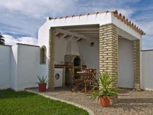a white patio with a table under awning at Casas Marin in Conil de la Frontera