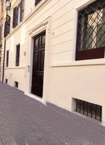 Angolo di Roma Guest house في روما: مبنى بابه اسود على شارع