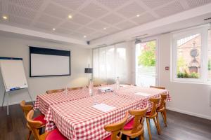 a conference room with a table and chairs and a screen at Hôtel Restaurant Notre Dame in Haguenau