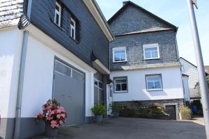 a white house with a black roof at Ferienhaus Laydeckersch in Mastershausen