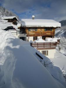 a house covered in snow next to a pile of snow at Chalet Etoile in Grimentz